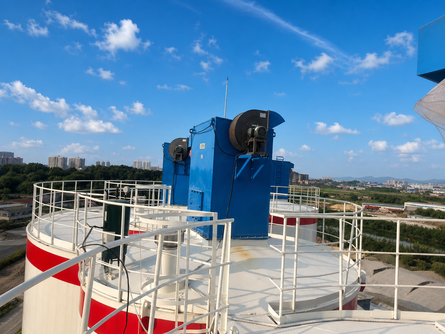 Blue silo dust collectors installed above dry bulk storage silos