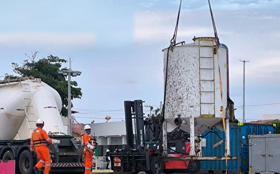 Non-standard rectangular storage vessel being transferred beside a truck